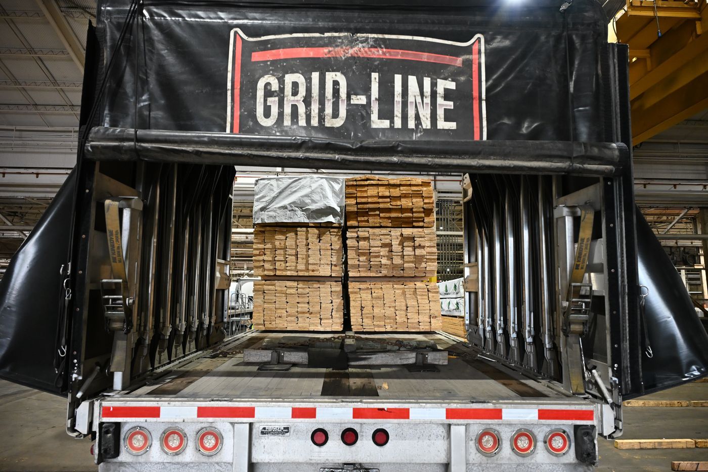 Lumber bundles loaded on a Grid-Line conestoga trailer