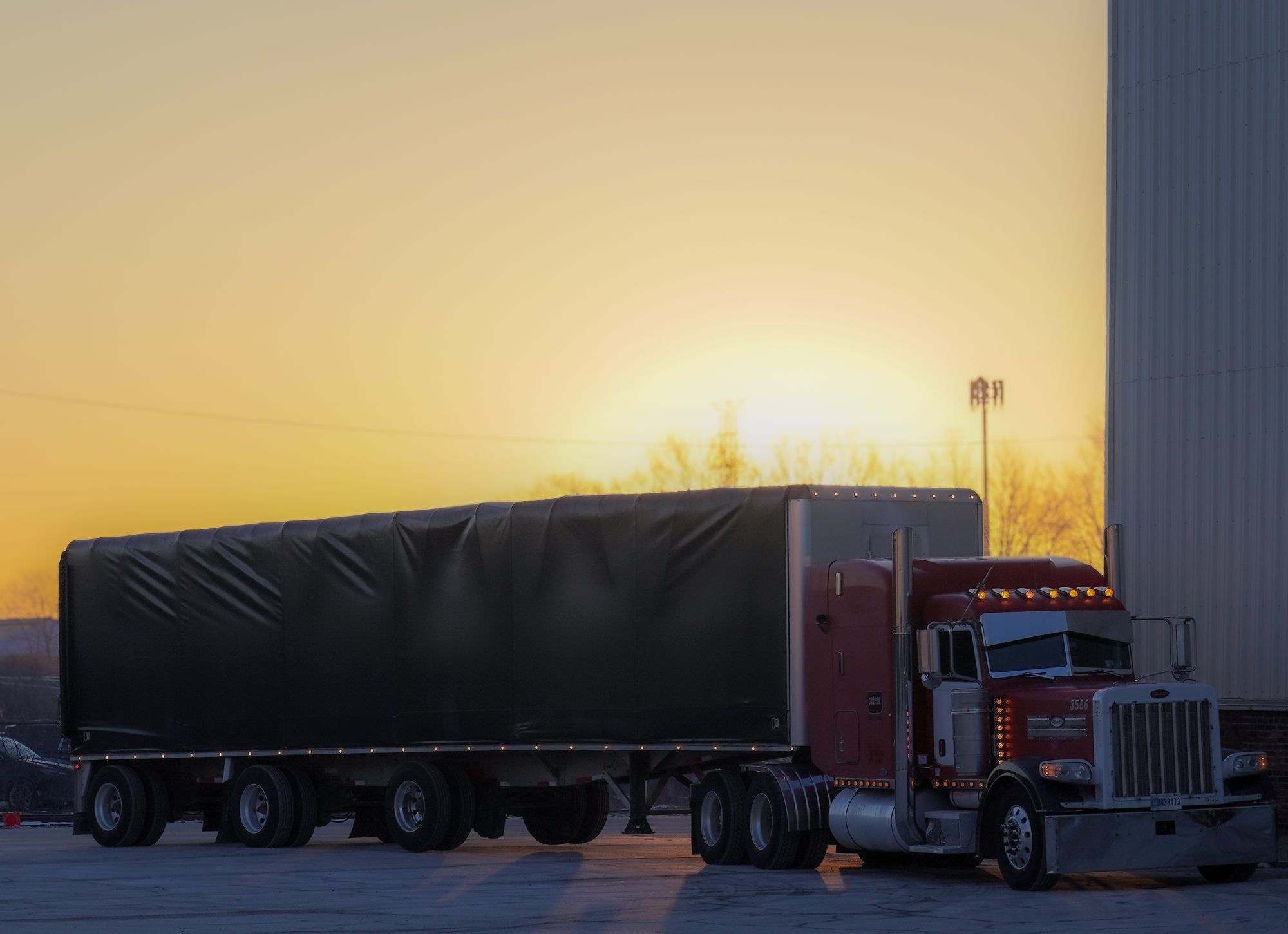 Tarped Grid-Line flatbed load at sunset