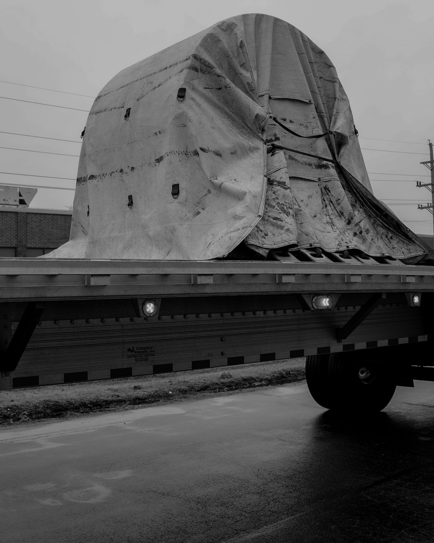 Tarped standup steel coil secured on a Grid-Line flatbed