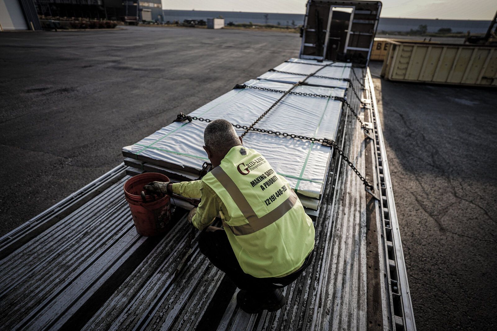 Driver pulling a tarp over a secured flatbed load